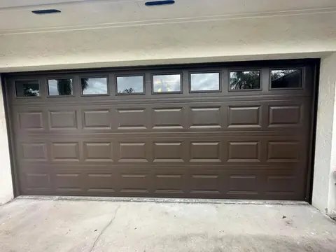 Brown raised-panel garage door with top windows